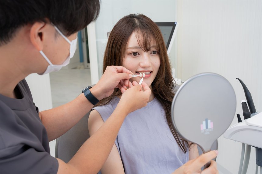 自然光の下でシェードガイドを用いて歯の色調を確認する様子